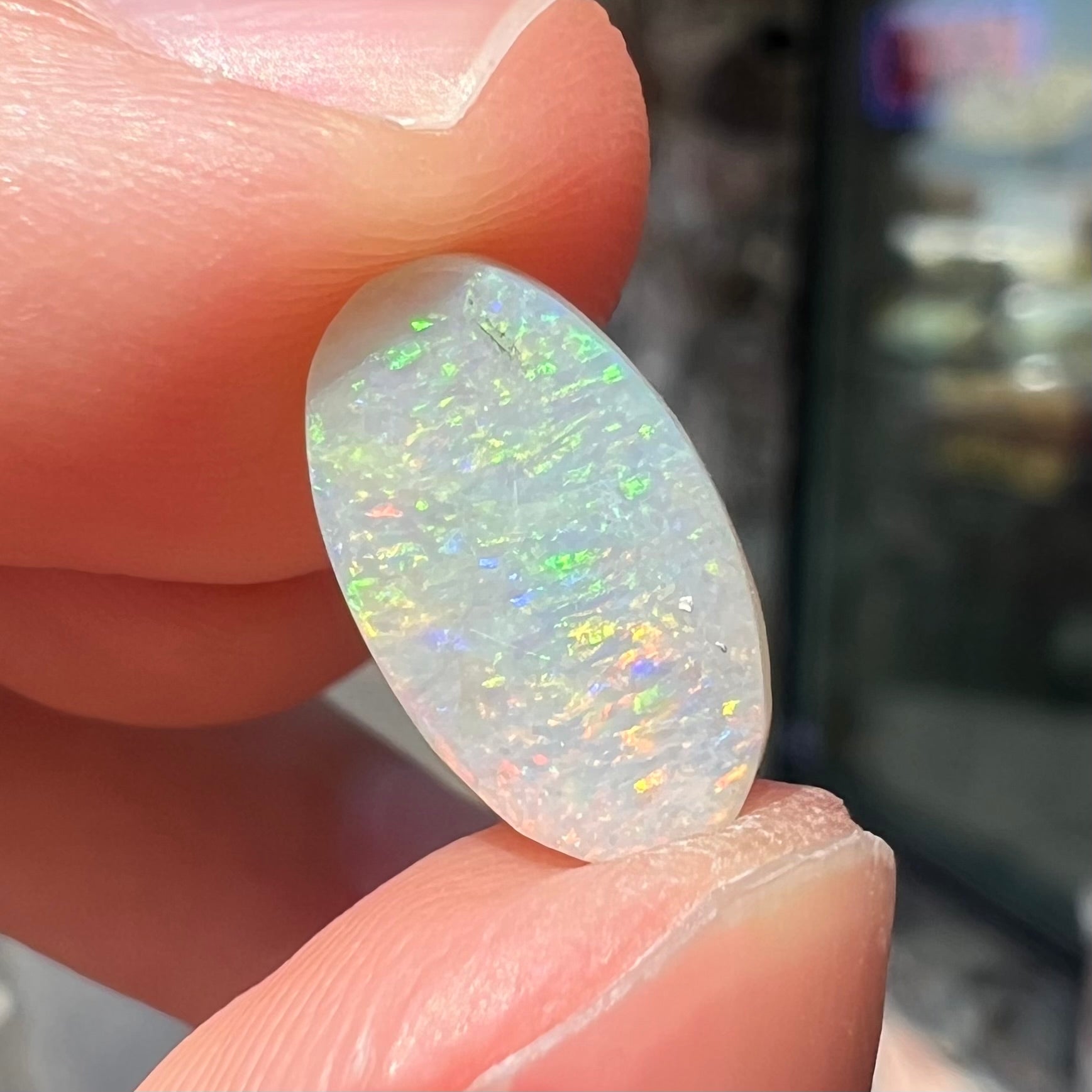 A loose, oval cabochon cut white opal stone from Coober Pedy, Australia.