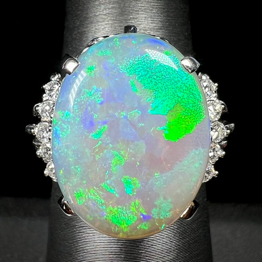 A platinum filigree ring set with a large, green-blue Mintabie crystal opal and diamonds.