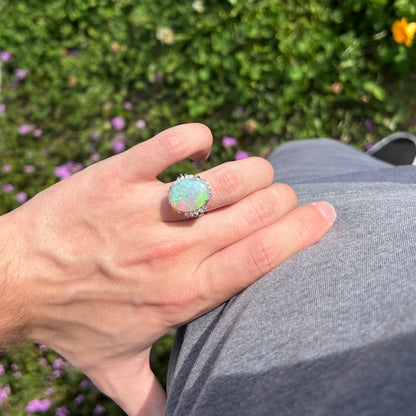 A platinum filigree engagement ring set with a large, green-blue Australian crystal opal.