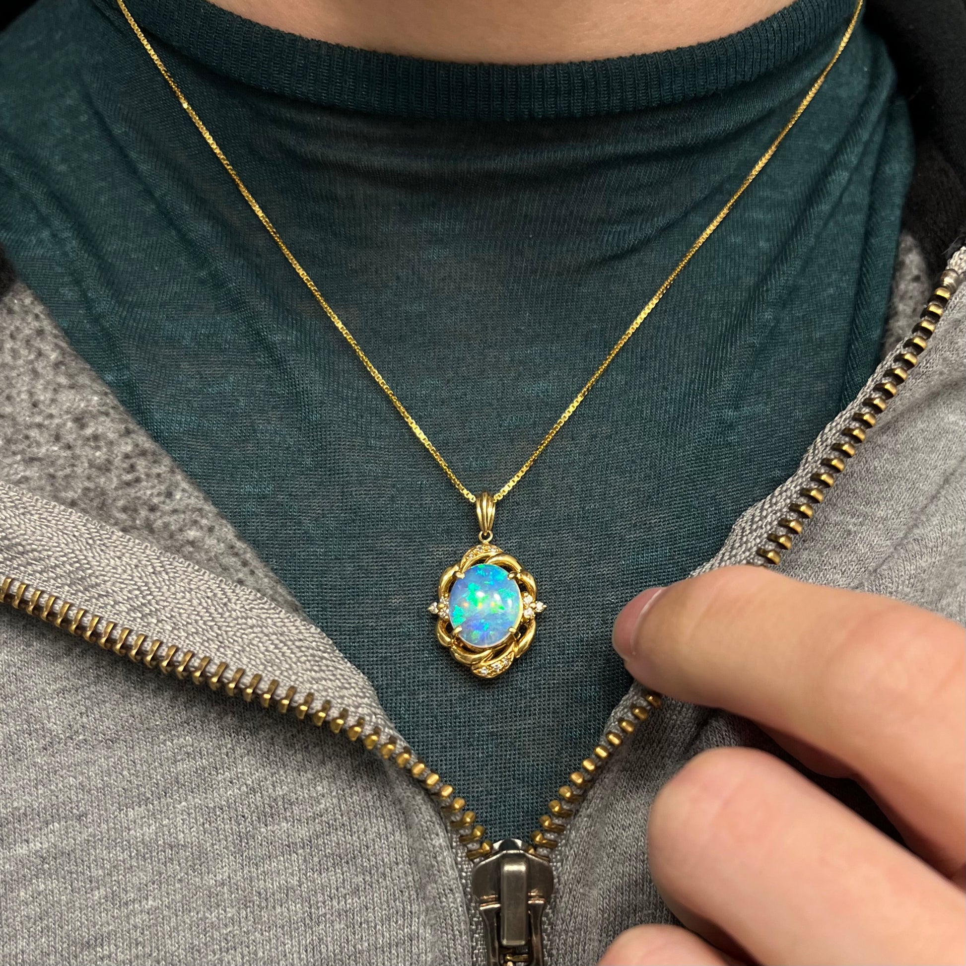 An 18 karat yellow gold diamond-accented necklace mounted with a green and blue Lightning Ridge crystal opal.