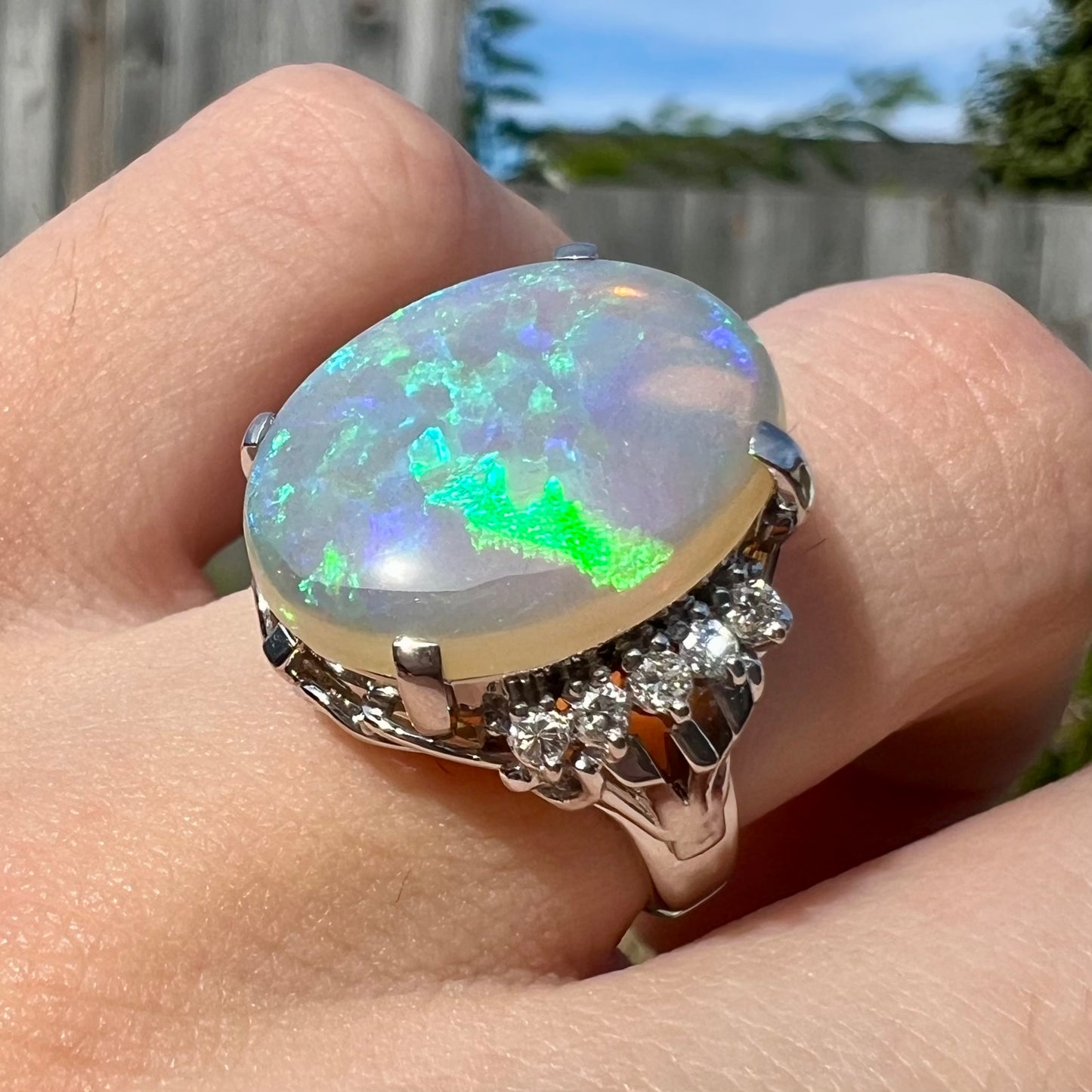 A platinum filigree engagement ring set with a large, green-blue Australian crystal opal.