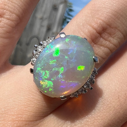 A platinum filigree engagement ring set with a large, green-blue Australian crystal opal.