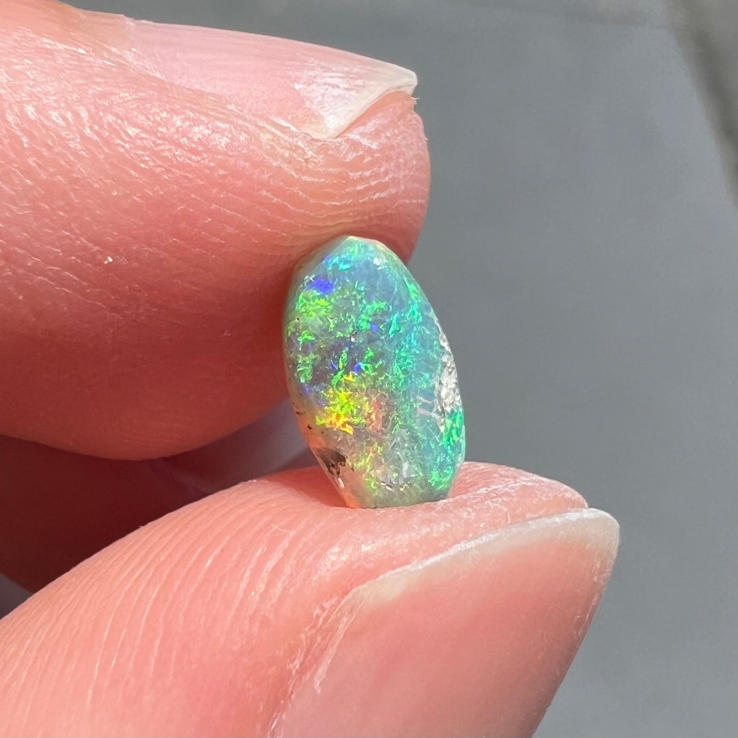 A loose, semi-crystal opal from Australia.  The opal predominantly show green and orange colors.