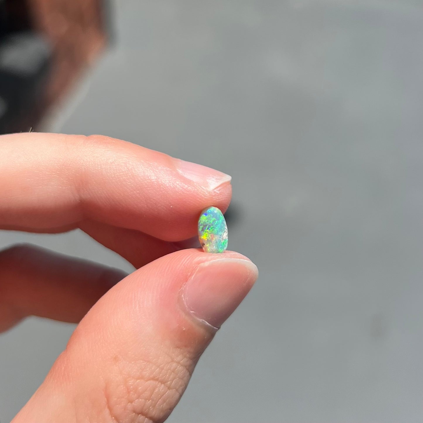 A loose, semi-crystal opal from Australia.  The opal predominantly show green and orange colors.