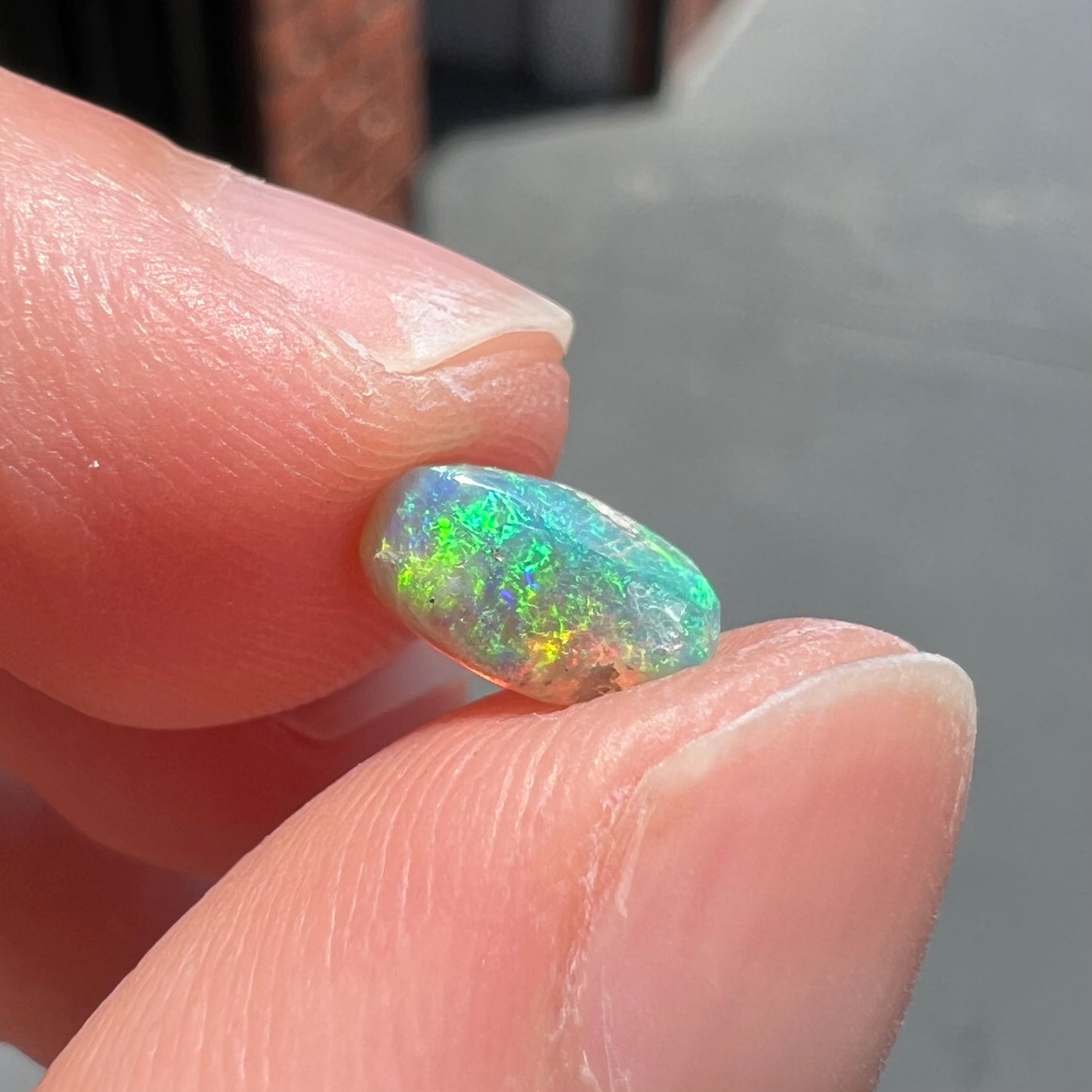 A loose, semi-crystal opal from Australia.  The opal predominantly show green and orange colors.