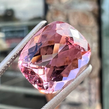 A loose, cushion cut light pink tourmaline gemstone.