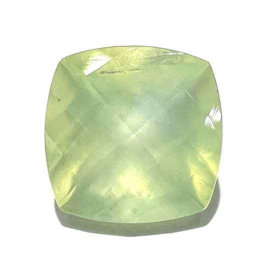 A loose, faceted checkerboard cushion cut green prehnite stone.  The stone is sleepy yellowish green.