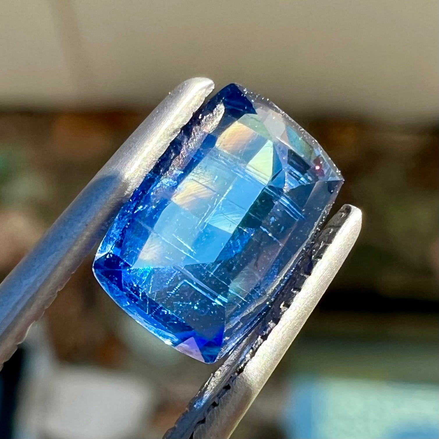 A loose, blue kyanite gemstone.  The stone is a faceted cushion cut.