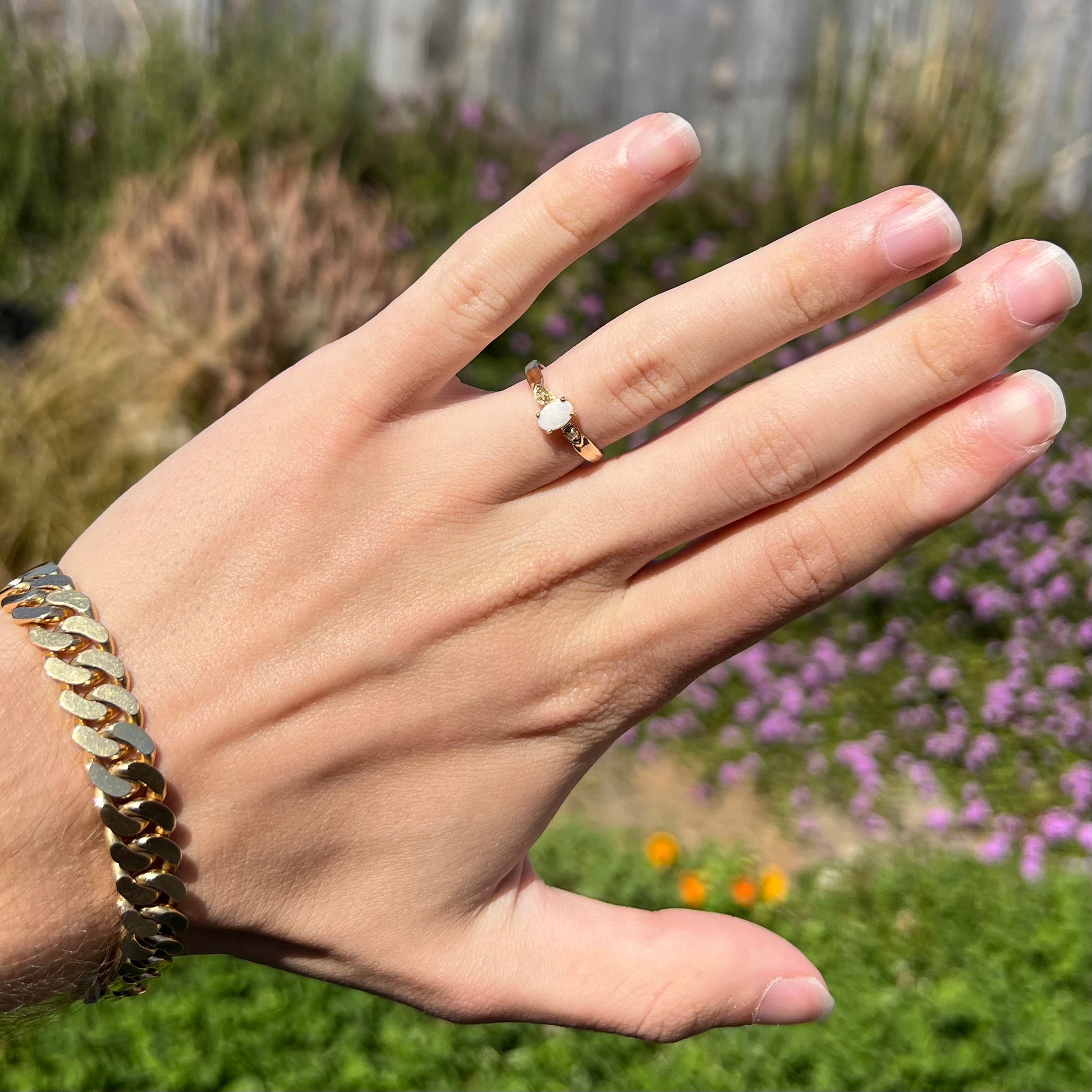 A dainty natural opal and diamond engagement ring in yellow gold.