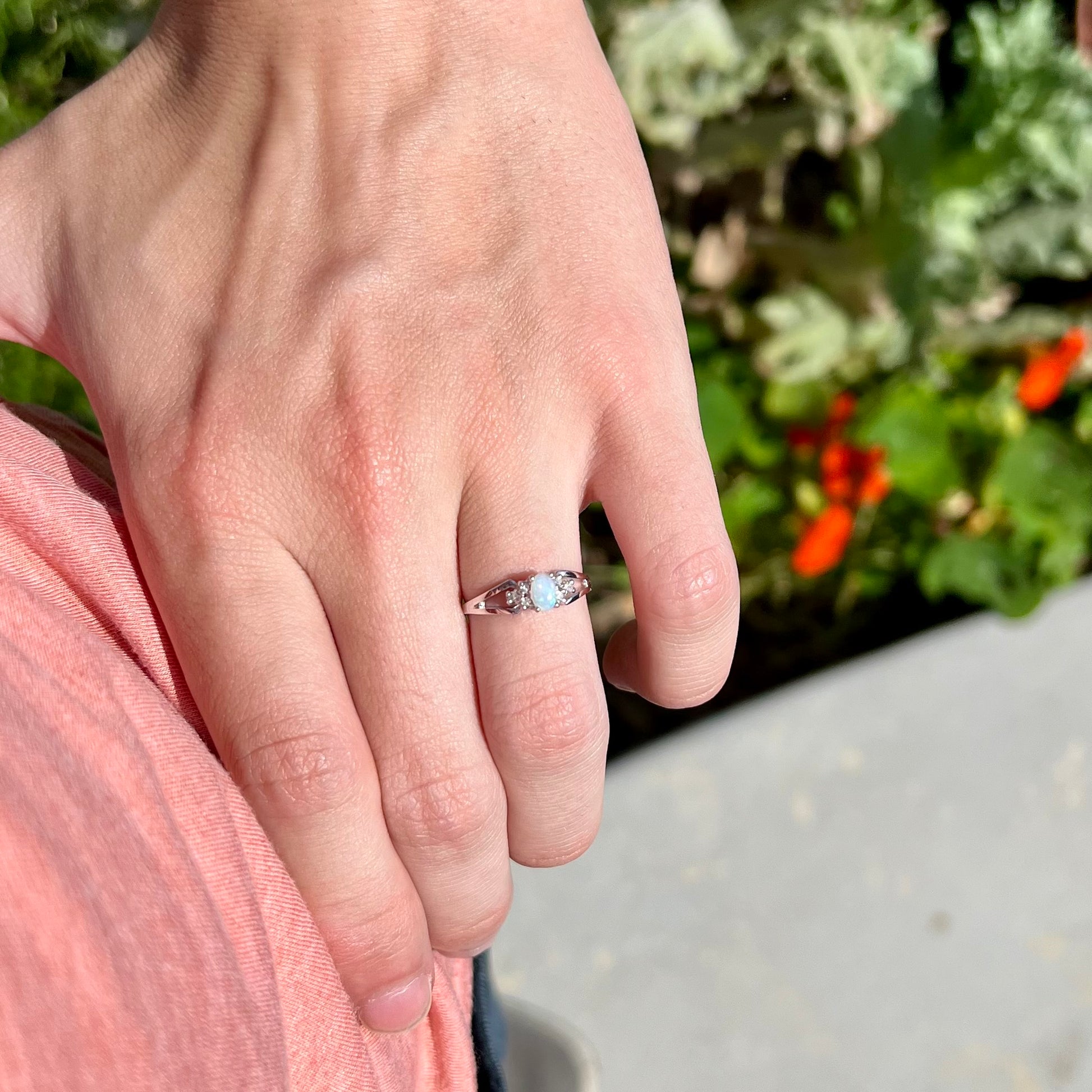 A ladies' white gold opal ring mounted with round diamond accents.