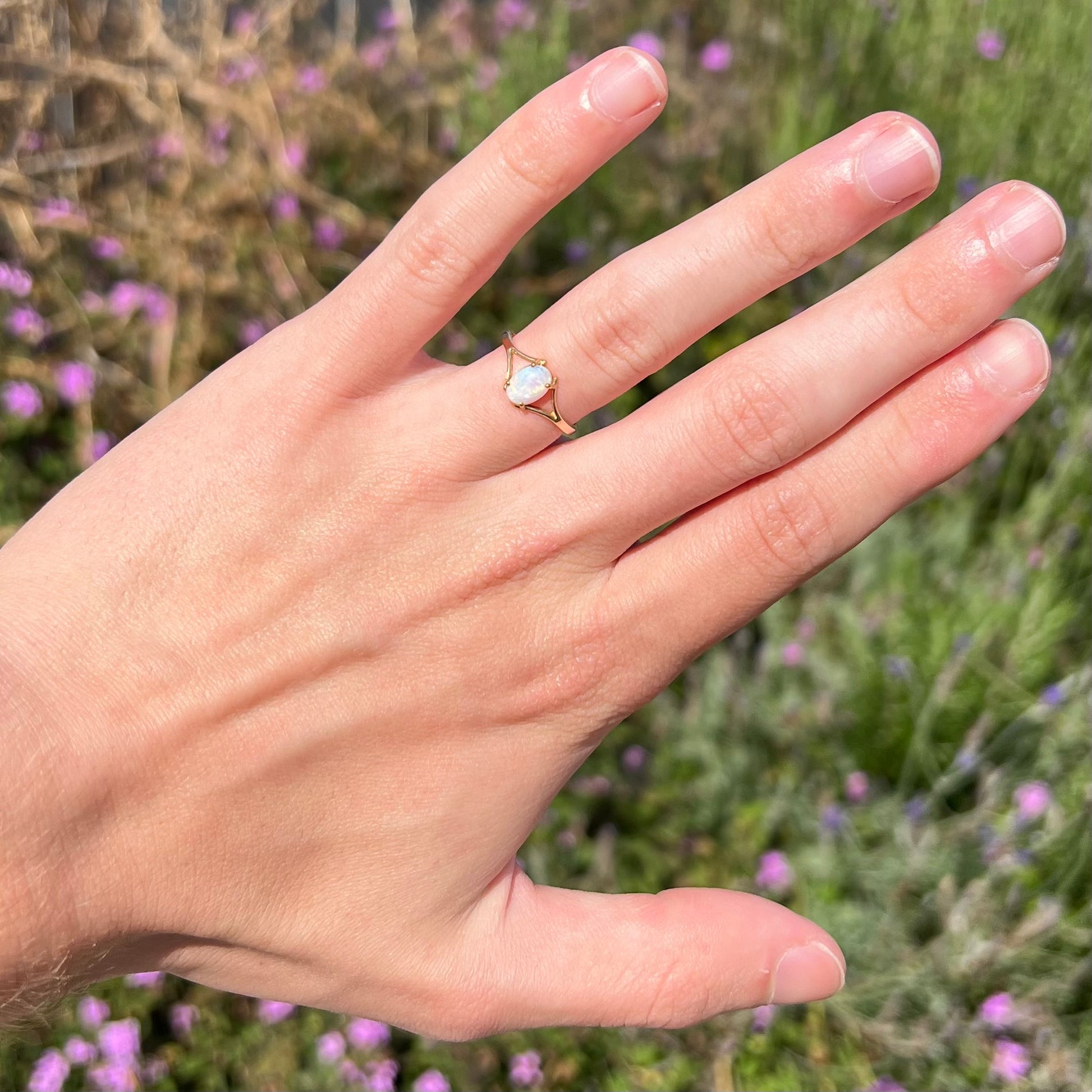 A ladies' simple opal solitaire ring.  The ring is yellow gold with a split shank.