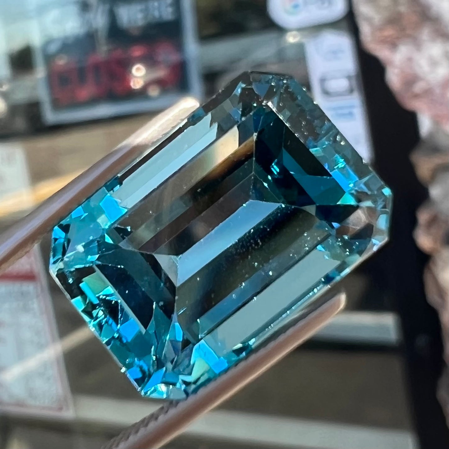 A loose, emerald cut London blue topaz gemstone.  The stone is a deep, dark blue color.