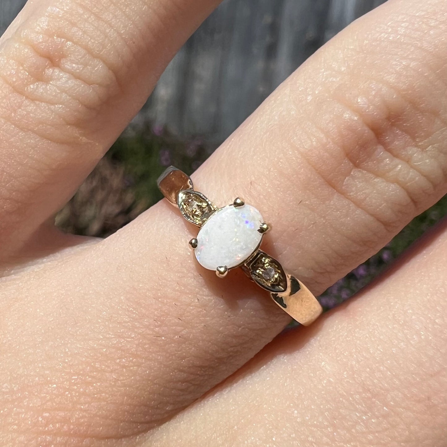 A dainty natural opal and diamond engagement ring in yellow gold.