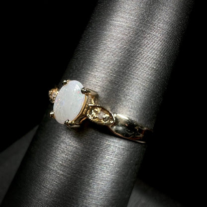 A dainty ladies' yellow gold opal and diamond ring.  The opal has subtle play of color.