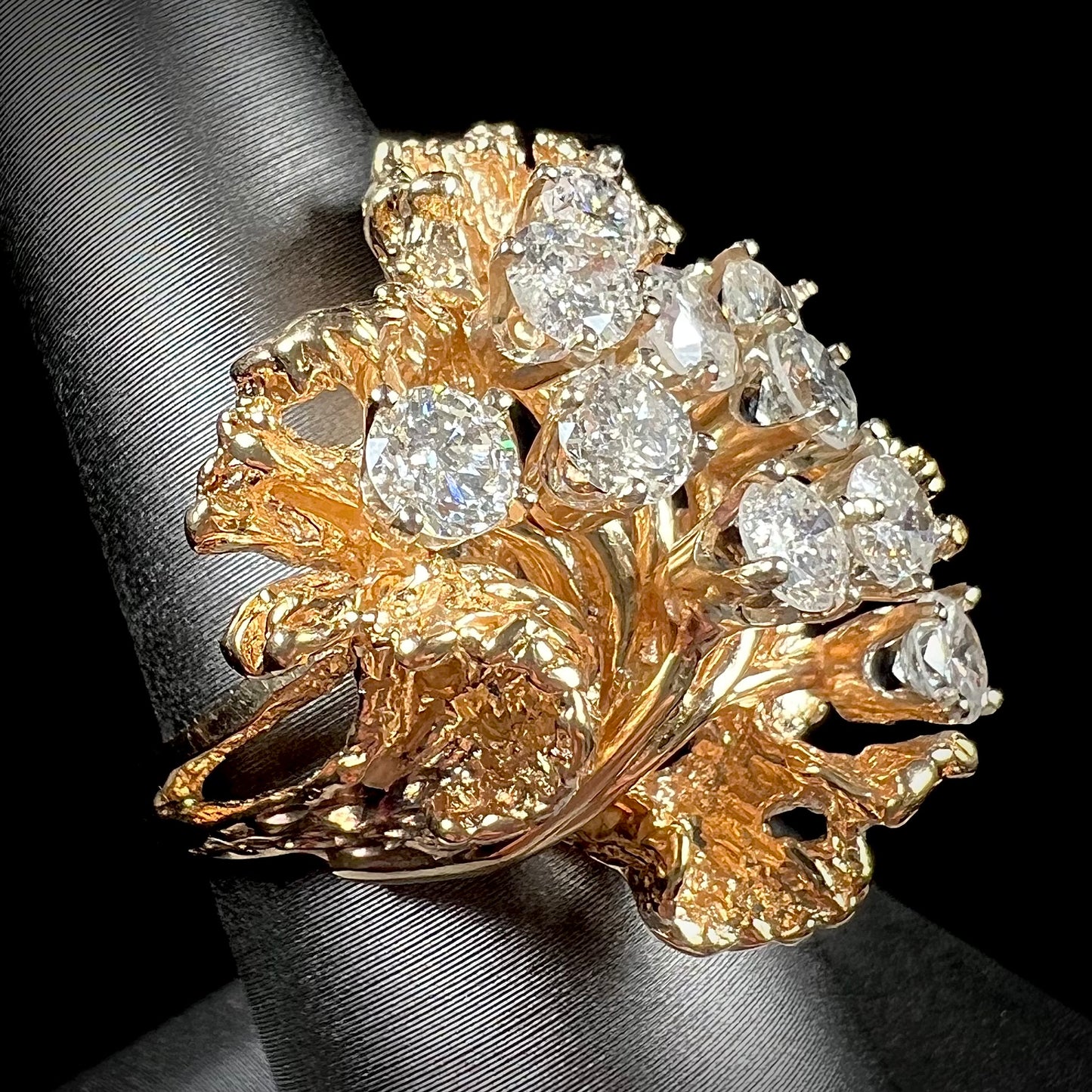 A ladies' 1950's style yellow gold and diamond cluster ring.  The ring is shaped like a leaf with 10 round diamonds set in it.