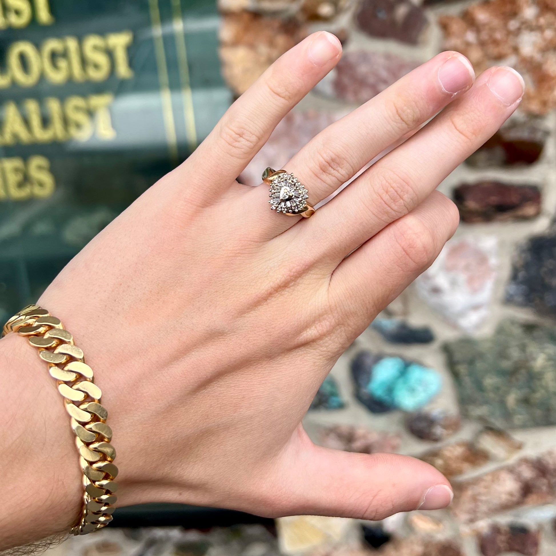 A ladies' heart shaped diamond cluster ring.  The ring is set with pear shaped, baguette cut, and round diamonds.