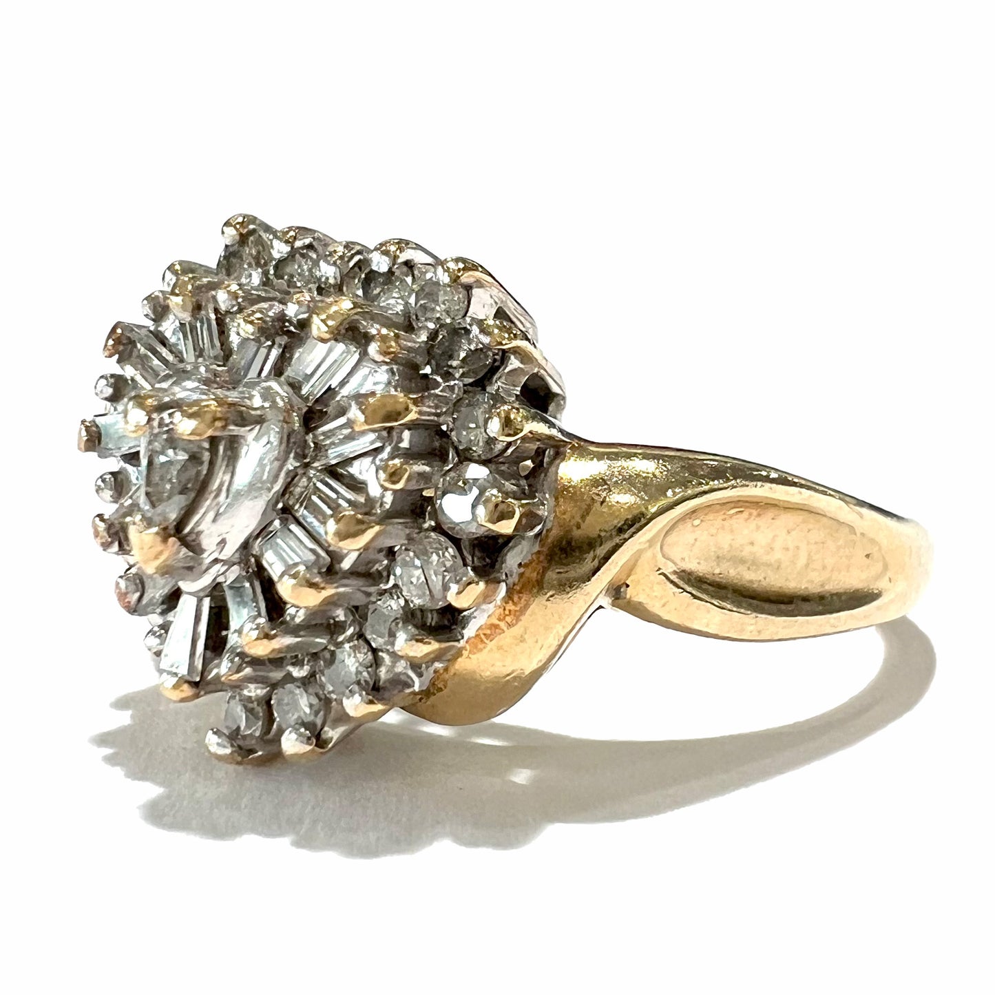 A ladies' heart shaped diamond cluster ring.  The ring is set with pear shaped, baguette cut, and round diamonds.