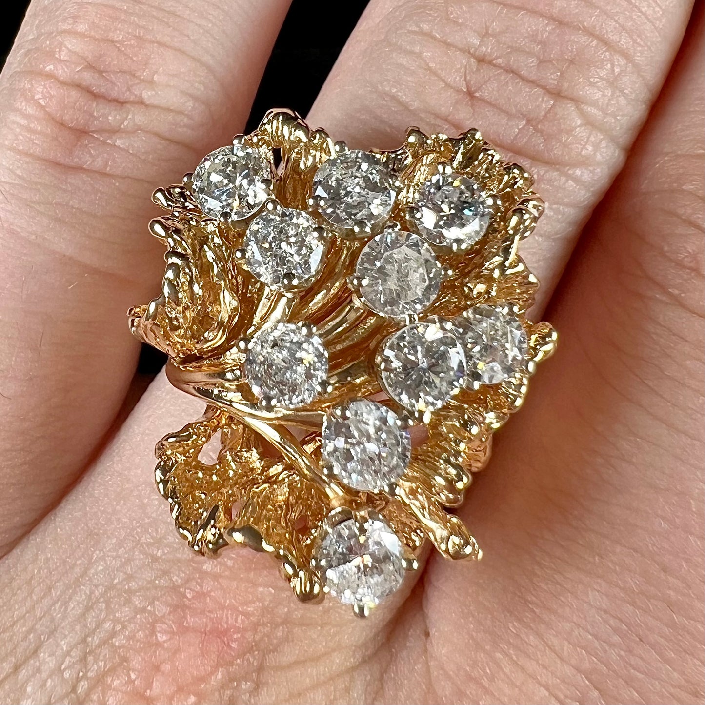 A ladies' 1950's style yellow gold and diamond cluster ring.  The ring is shaped like a leaf with 10 round diamonds set in it.