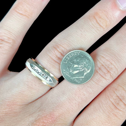 A unisex, two-tone white and yellow gold diamond wedding band.  The white gold is textured.