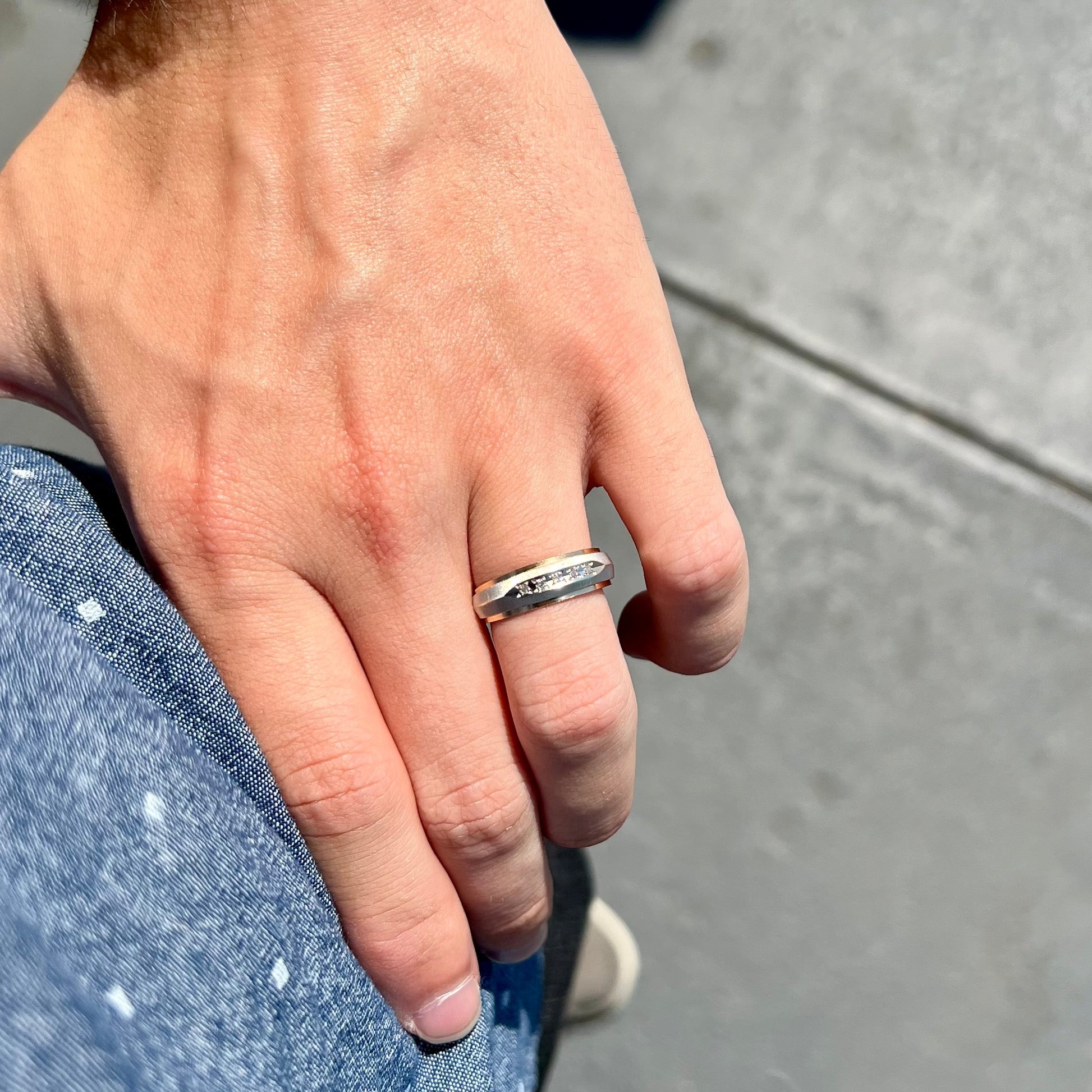 A unisex, two-tone white and yellow gold diamond wedding band.  The white gold is textured.