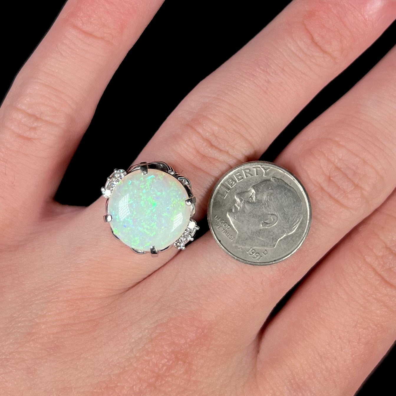 A round cut Australian opal and diamond engagment ring with platinum filigree.