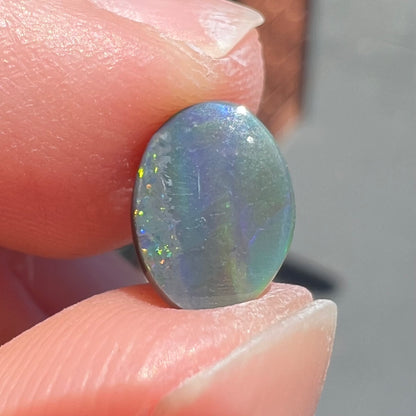 A loose, oval cut black opal from Lighting Ridge, Australia.  The stone is highly directional.