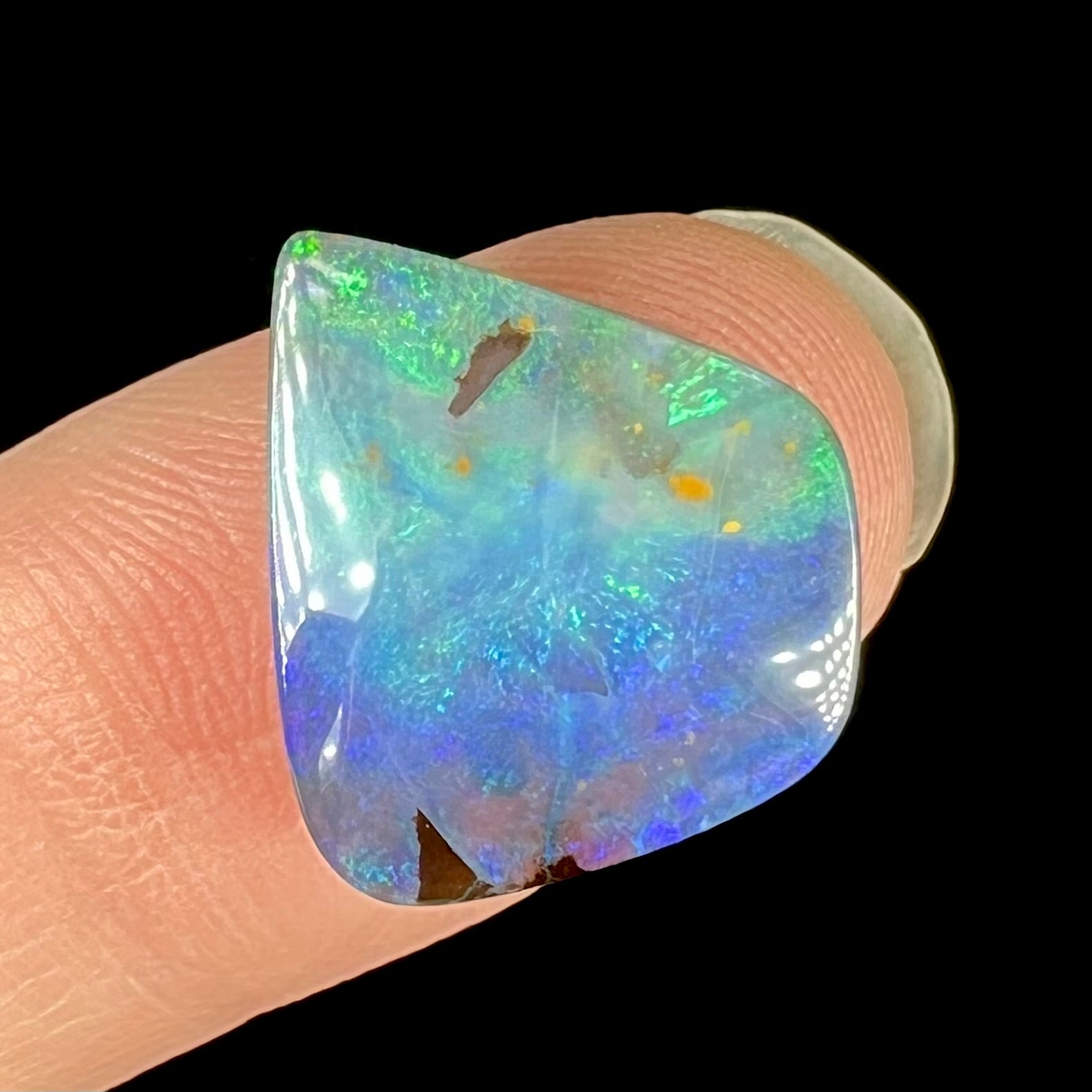 A loose, freeform shaped double-sided boulder opal stone from Quilpie, Australia.  One side is blue, the other is white.