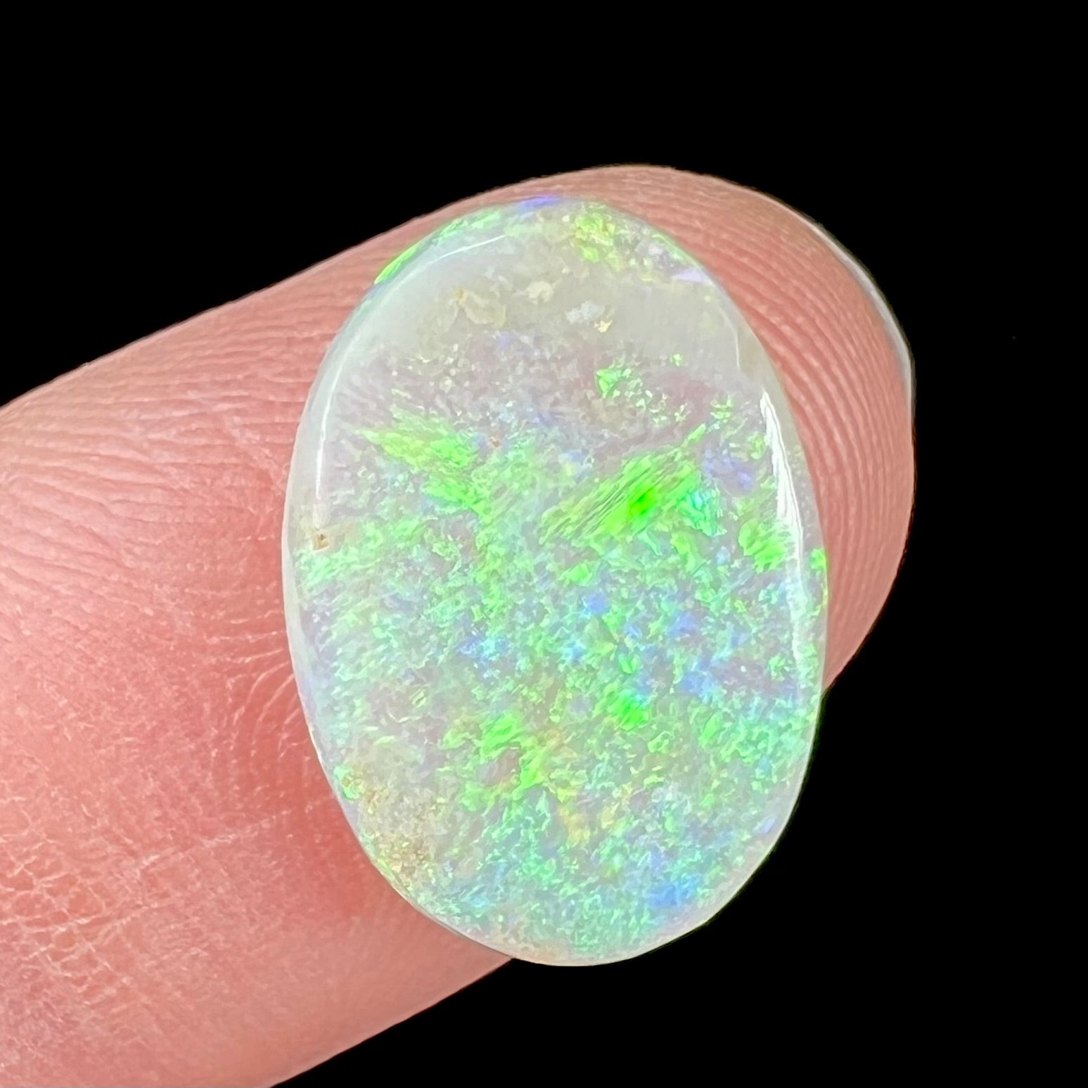 A double-sided opal stone from Coober Pedy, Australia.  The opal plays green, blue, and orange colors from the front and the back.