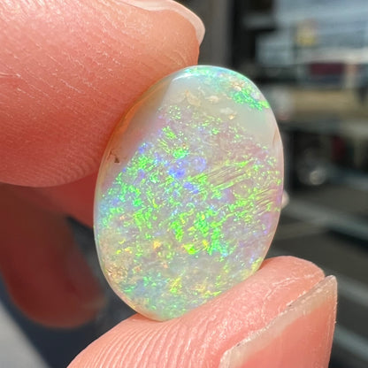 A double-sided opal stone from Coober Pedy, Australia.  The opal plays green, blue, and orange colors from the front and the back.