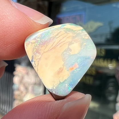 A loose, freeform shaped double-sided boulder opal stone from Quilpie, Australia.  One side is blue, the other is white.