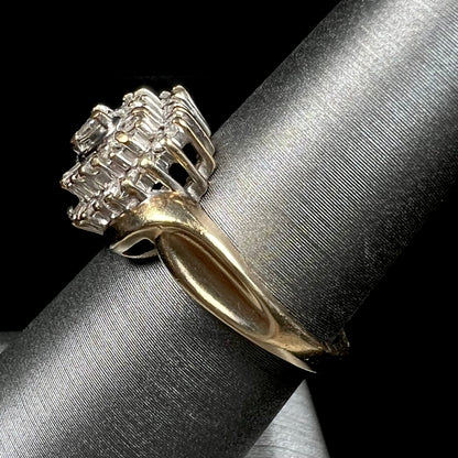 A ladies' heart shaped diamond cluster ring.  The ring is set with pear shaped, baguette cut, and round diamonds.