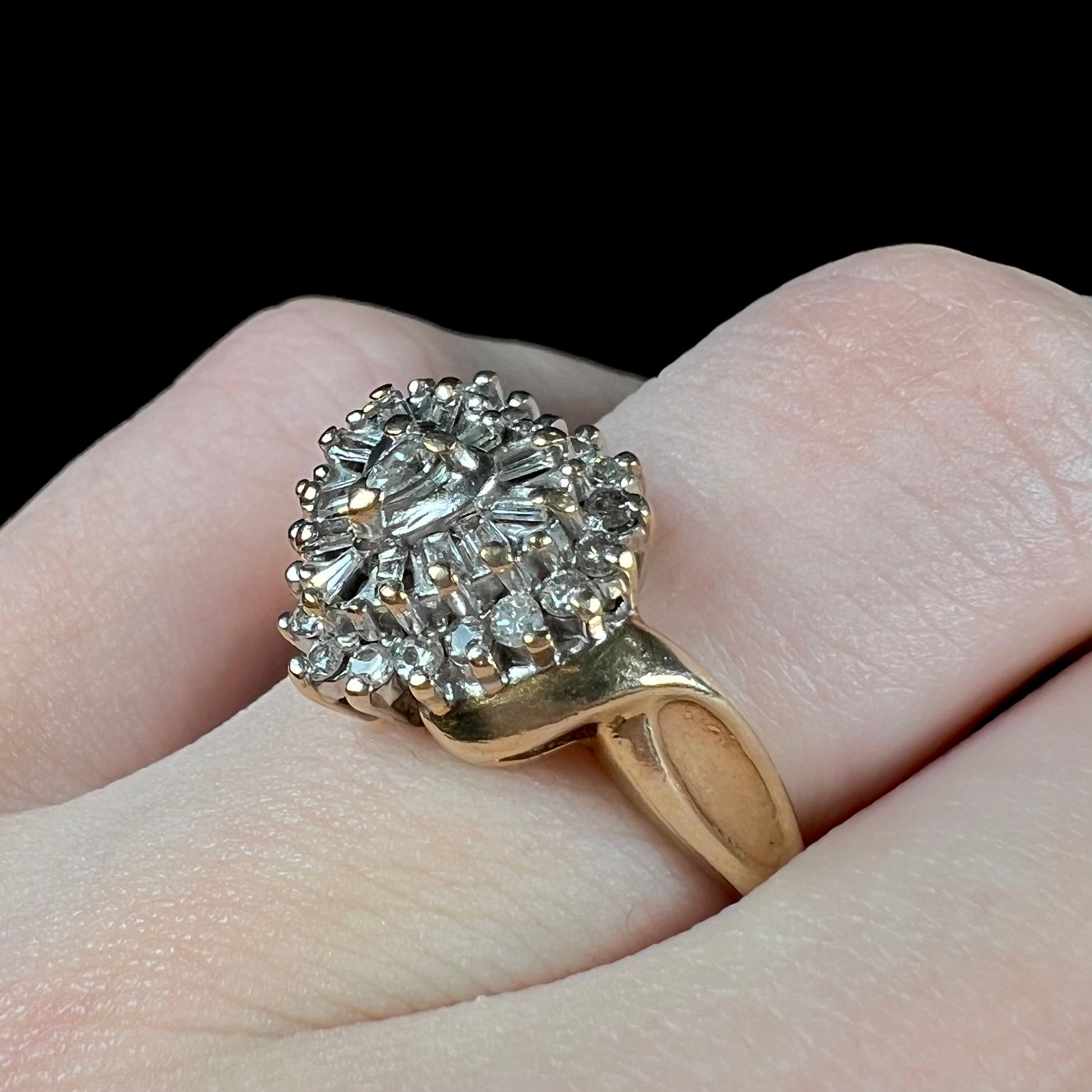 A ladies' heart shaped diamond cluster ring.  The ring is set with pear shaped, baguette cut, and round diamonds.