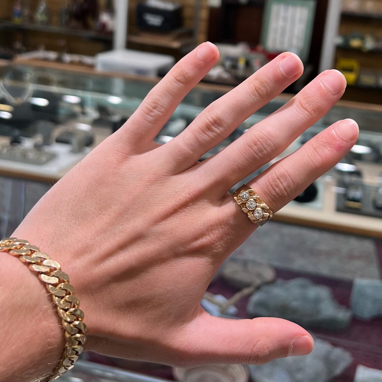 A men's yellow gold ring set with three round brilliant cut diamonds.  There are scratches along the shank.