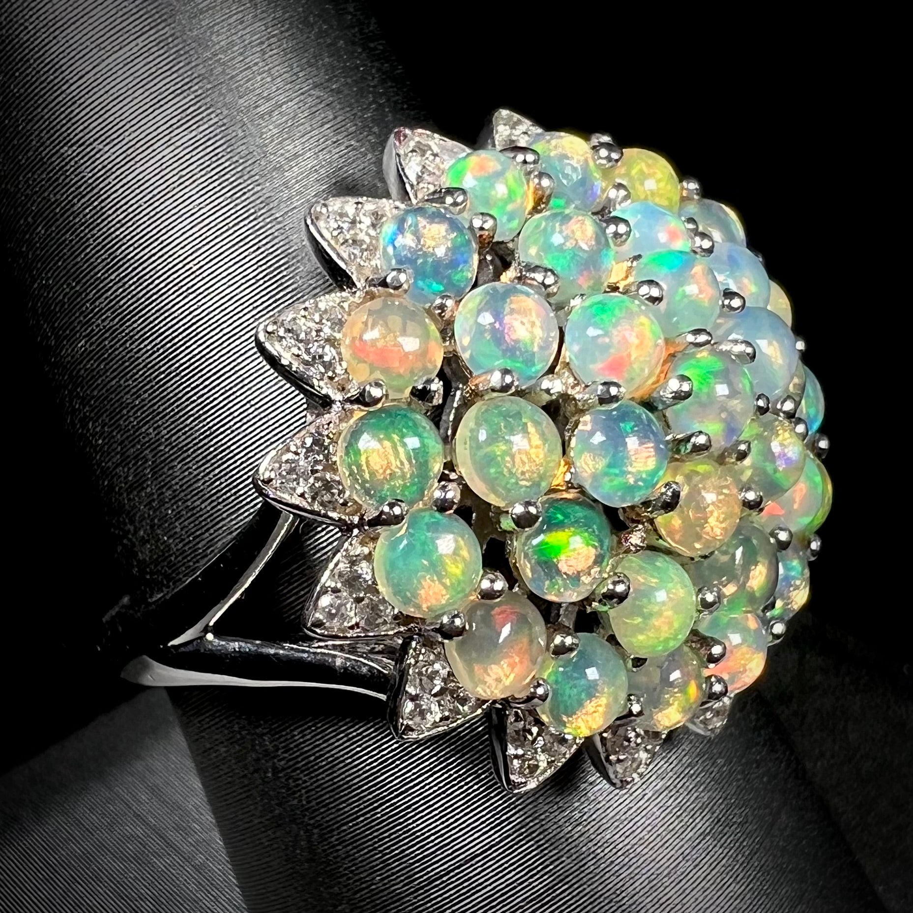 A sterling silver cluster flower ring mounted with 33 round Ethiopian fire opals.