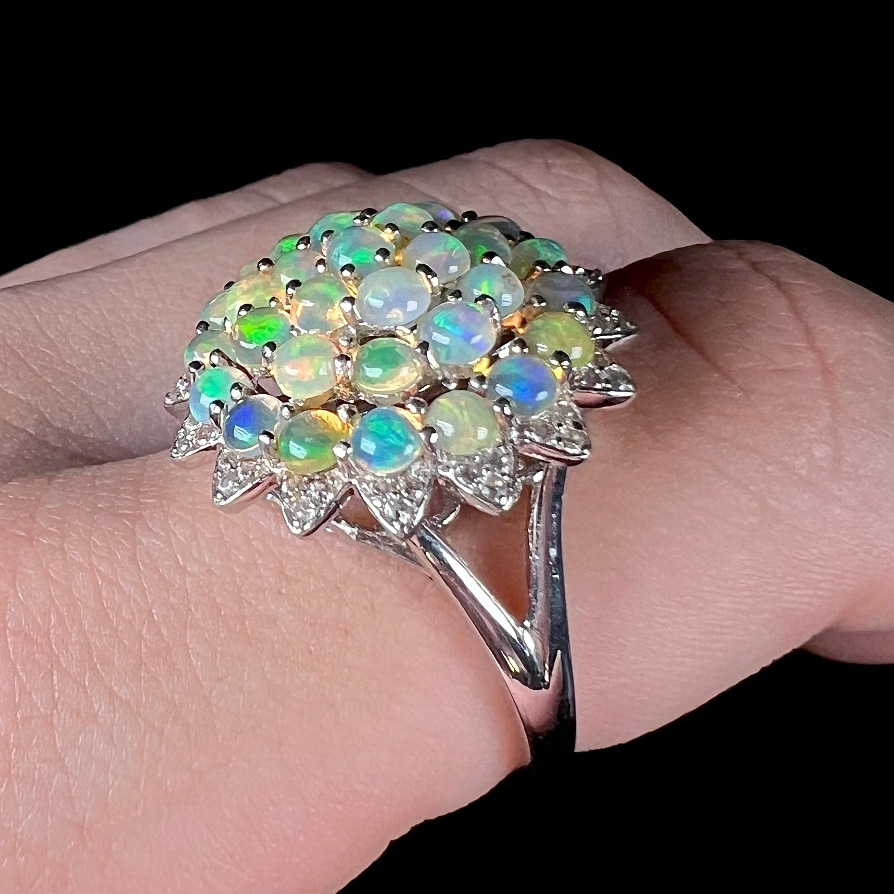 A sterling silver cluster flower ring mounted with 33 round Ethiopian fire opals.