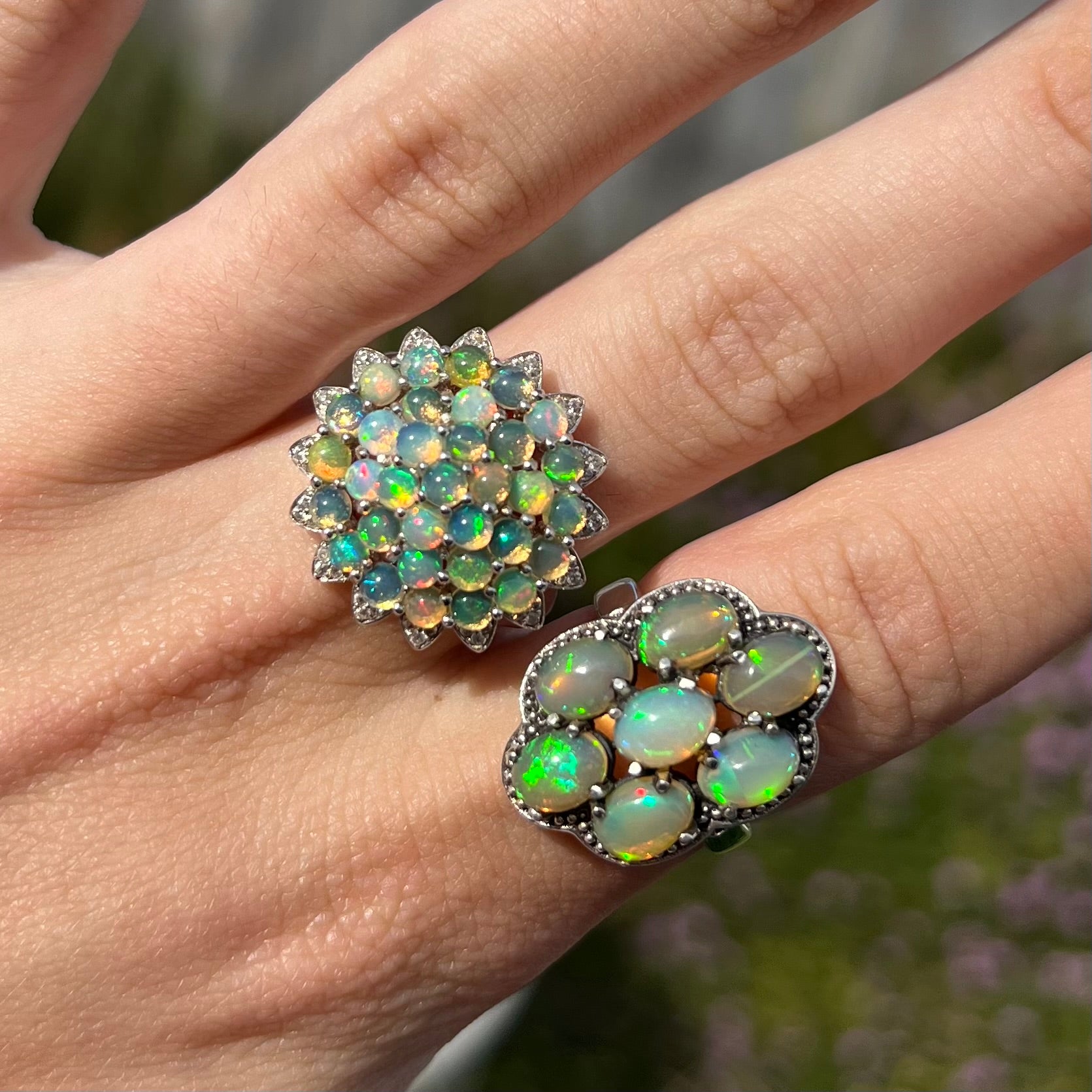 A pair of sterling silver cluster rings prong-set with green Ethiopian fire opals.