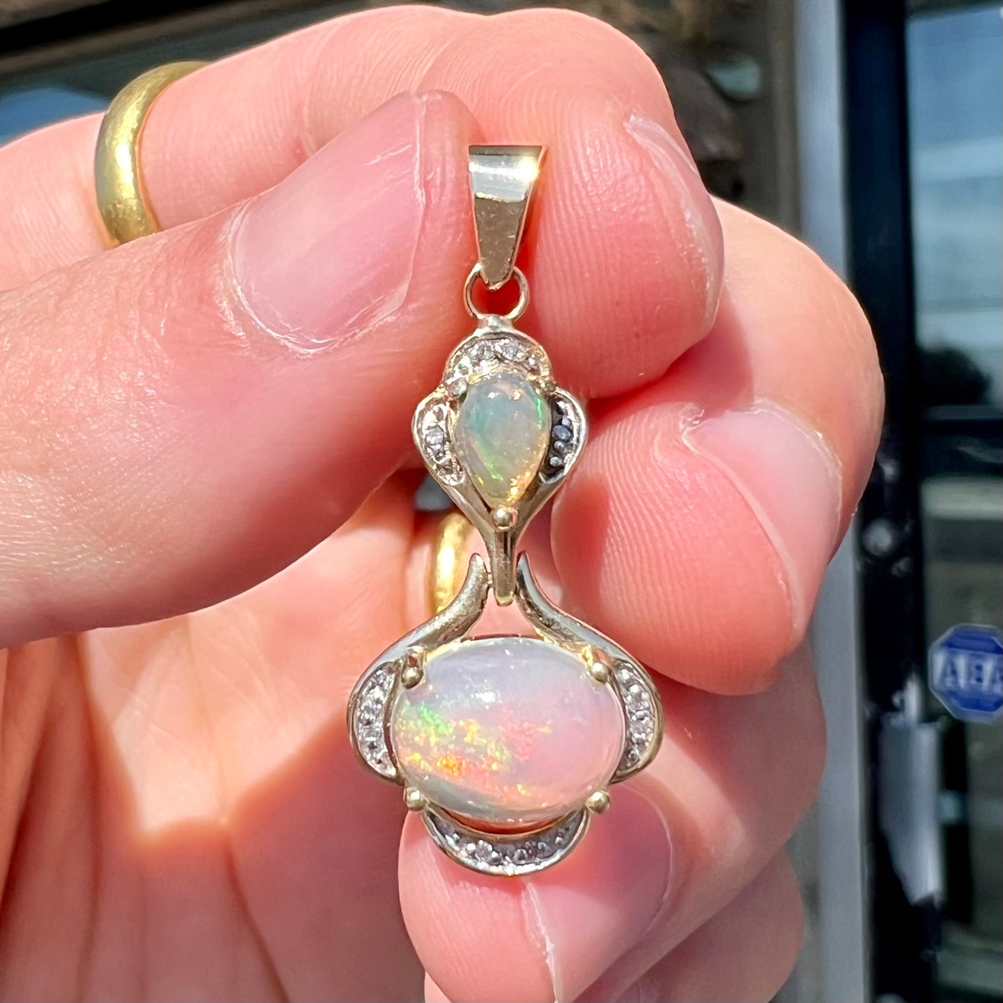 A ladies' yellow gold and diamond accented pendant set with two natural Ethiopian fire opals.