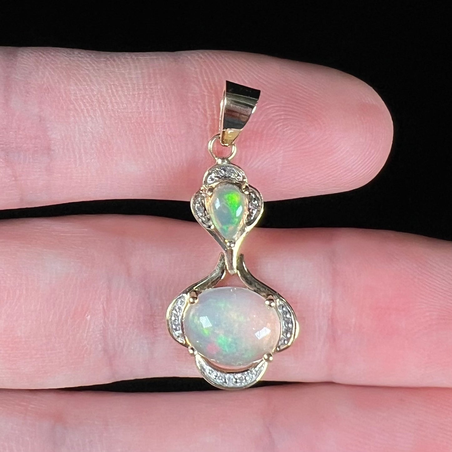 A ladies' yellow gold and diamond accented pendant set with two natural Ethiopian fire opals.