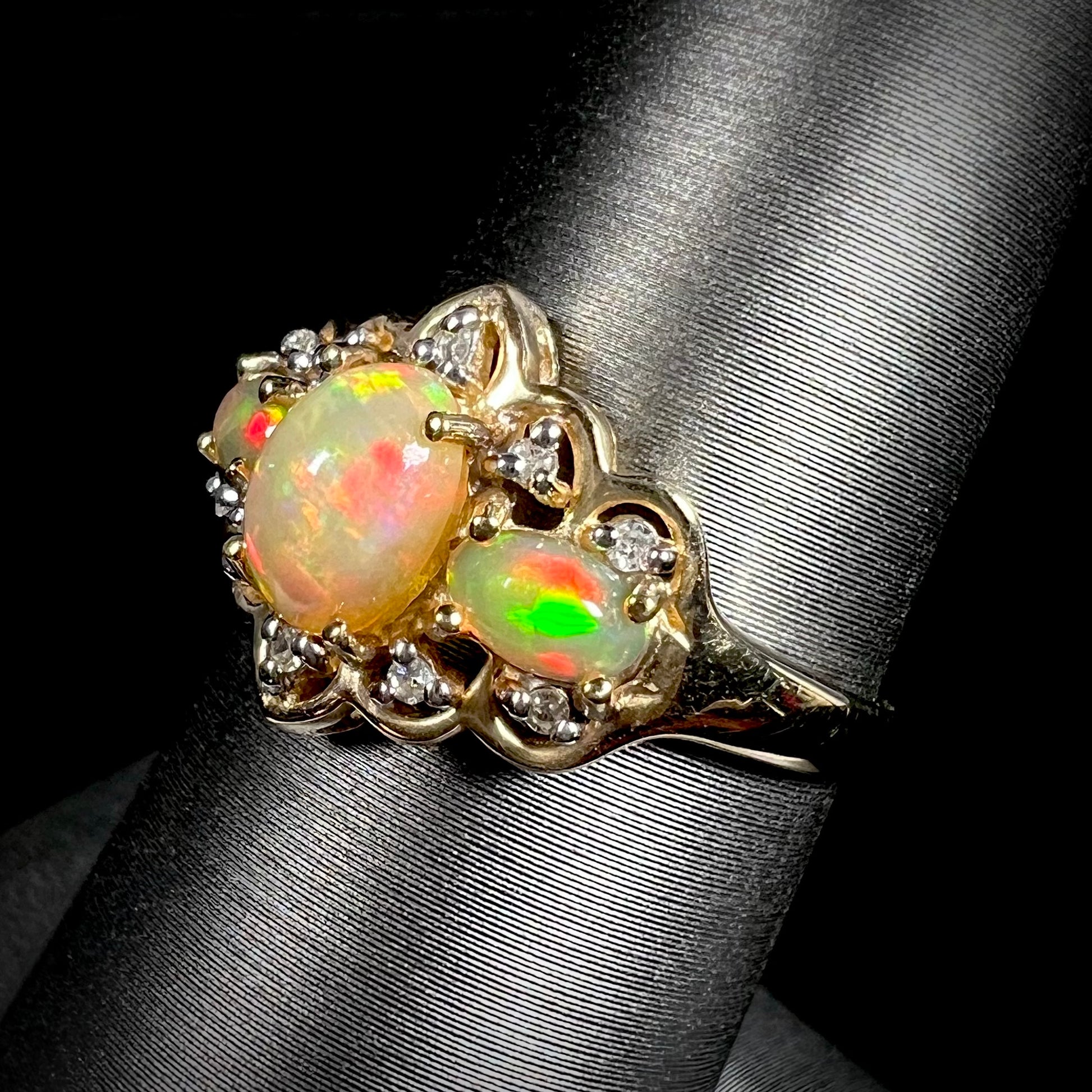 A three-stone gold ring set with Ethiopian fire opals and diamond accents.