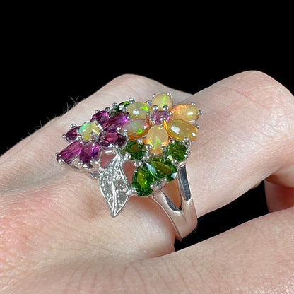 A ladies' gemstone flower design cluster ring set with Ethiopian fire opals, chrome diopsides, rhodolite garnets, and white topaz stones.