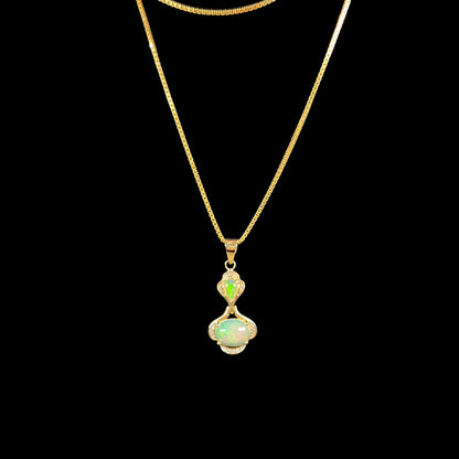 A ladies' yellow gold and diamond accented pendant set with two natural Ethiopian fire opals.