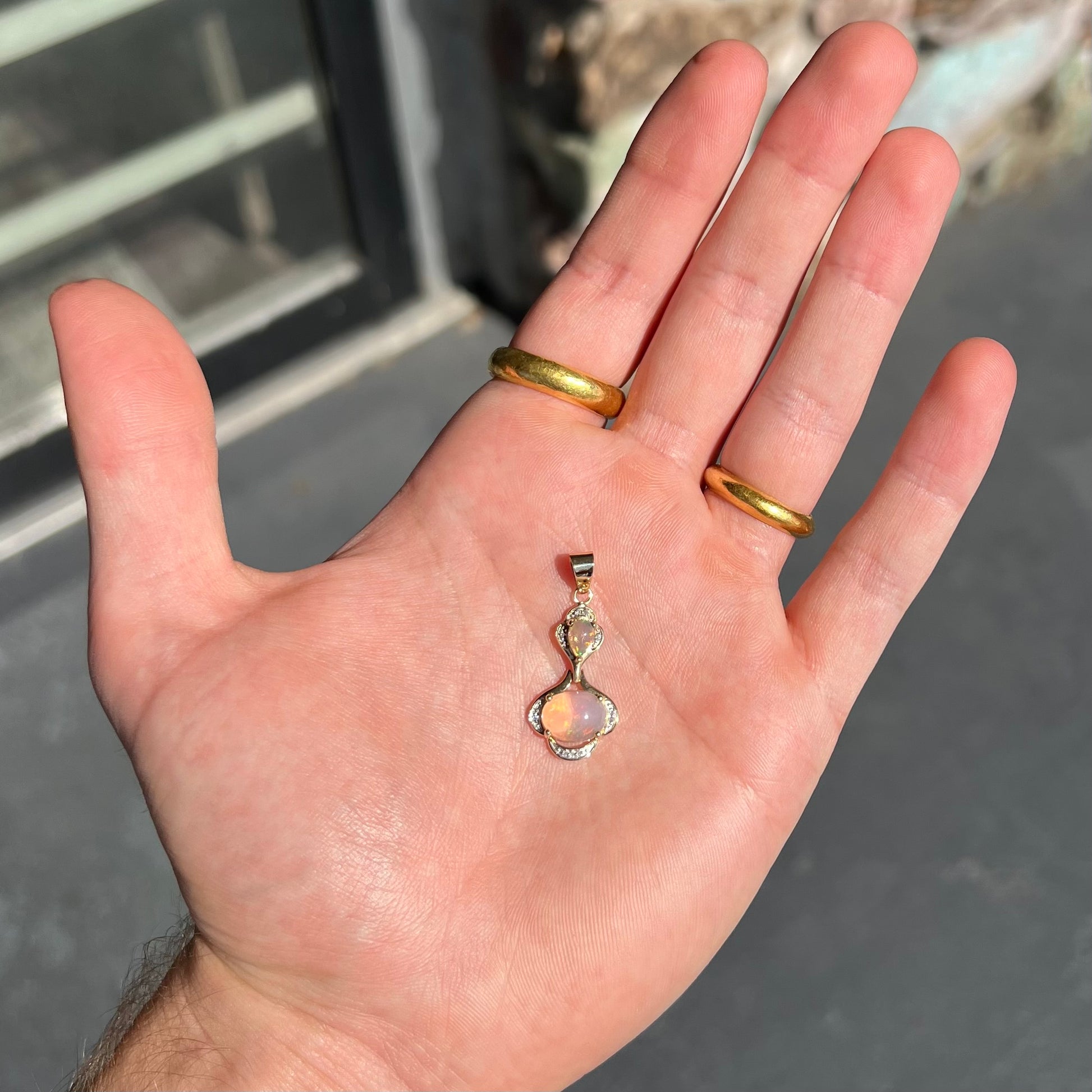 A ladies' yellow gold and diamond accented pendant set with two natural Ethiopian fire opals.