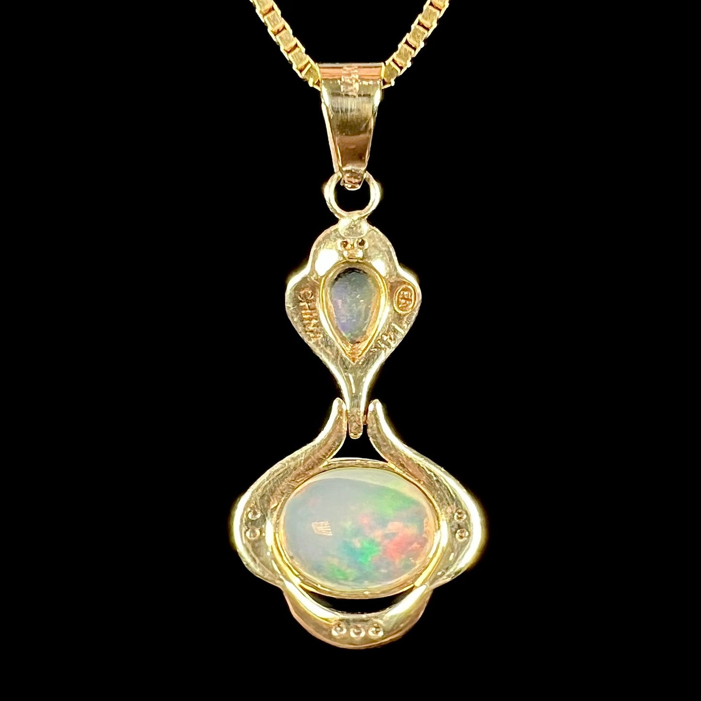 A ladies' yellow gold and diamond accented pendant set with two natural Ethiopian fire opals.