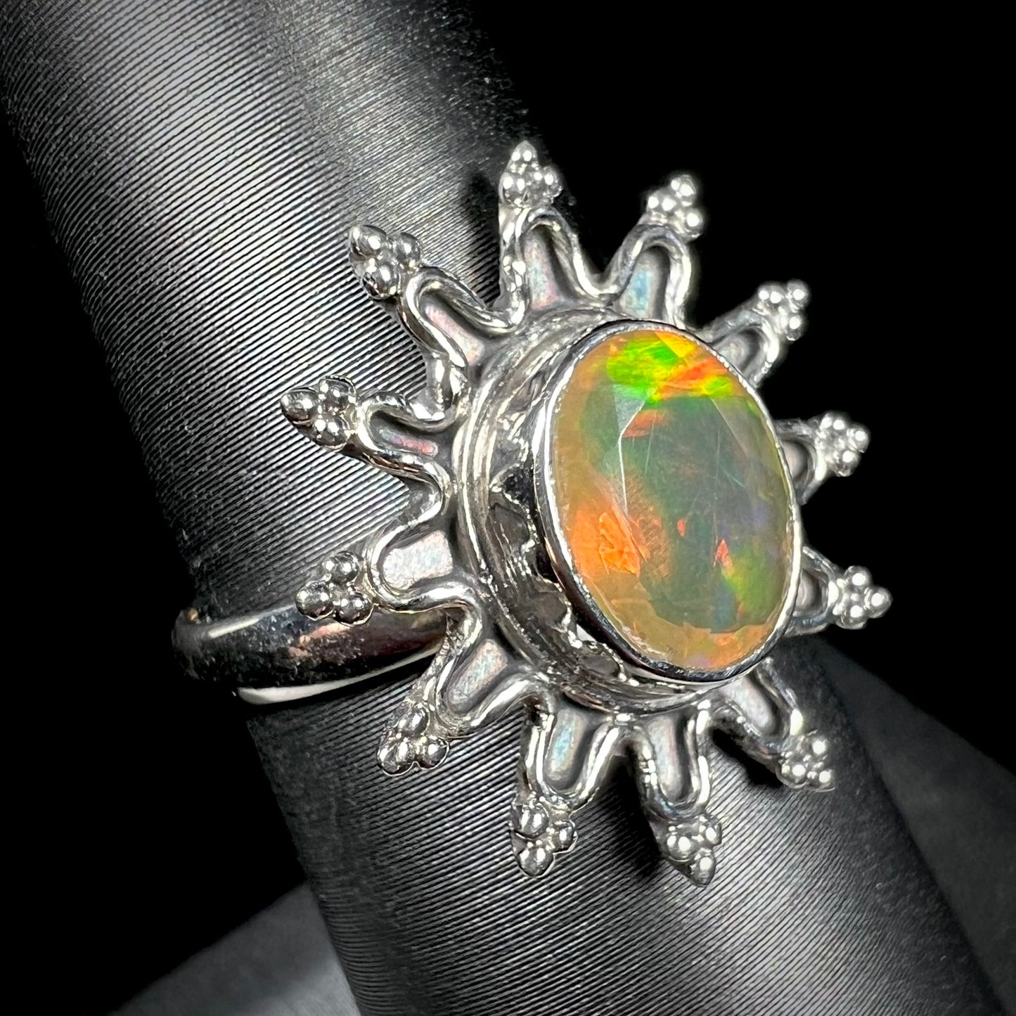 A sterling silver sunburst-style ring mounted with a faceted oval cut Ethiopian fire opal.