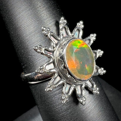 A sterling silver sunburst-style ring mounted with a faceted oval cut Ethiopian fire opal.