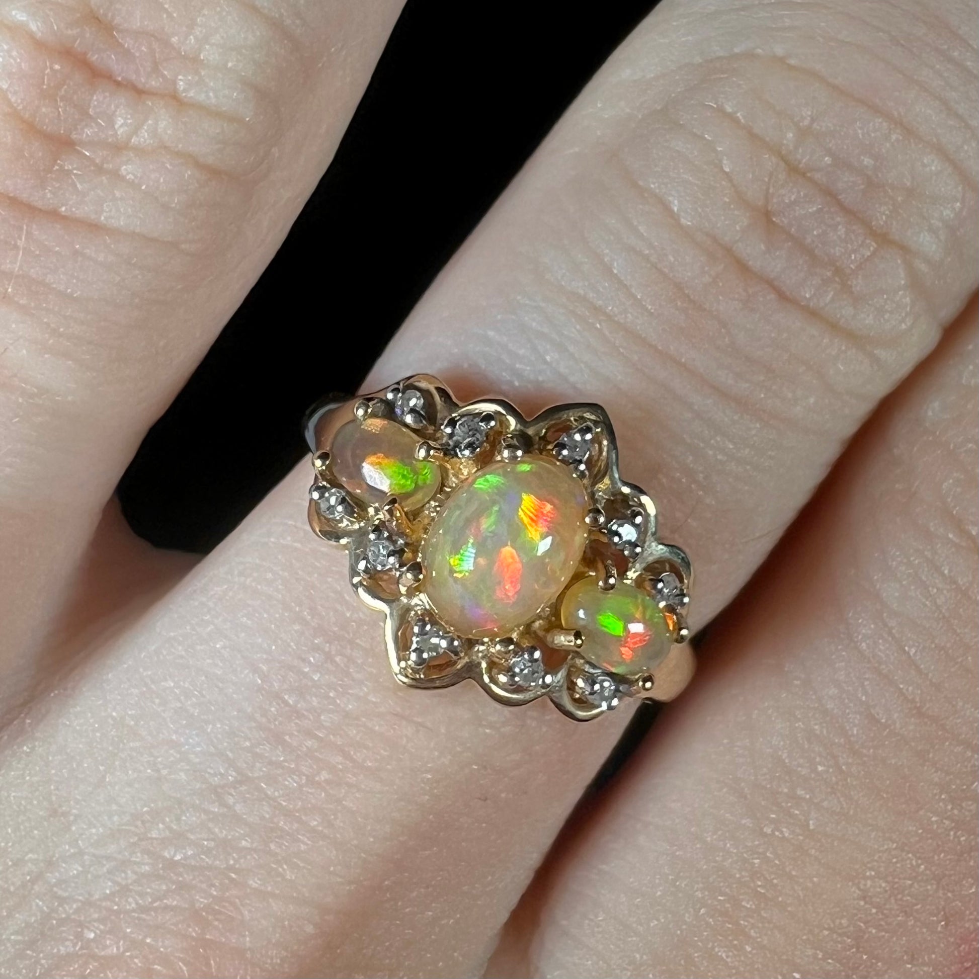 A three-stone gold ring set with Ethiopian fire opals and diamond accents.