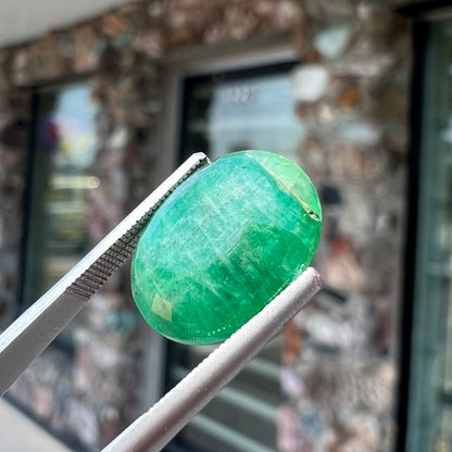 A loose, faceted oval cut commercial grade emerald stone.