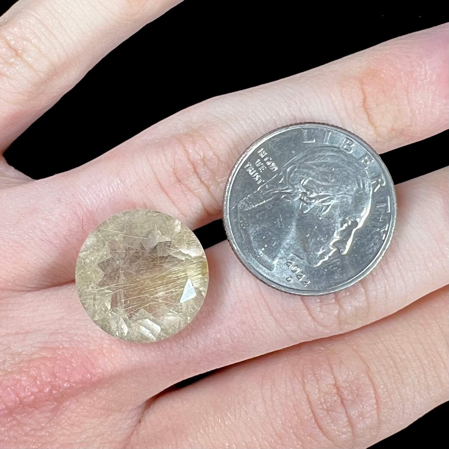 A loose, modified Early American round cut rutilated quartz gemstone.  The rutile inclusions are a golden color.