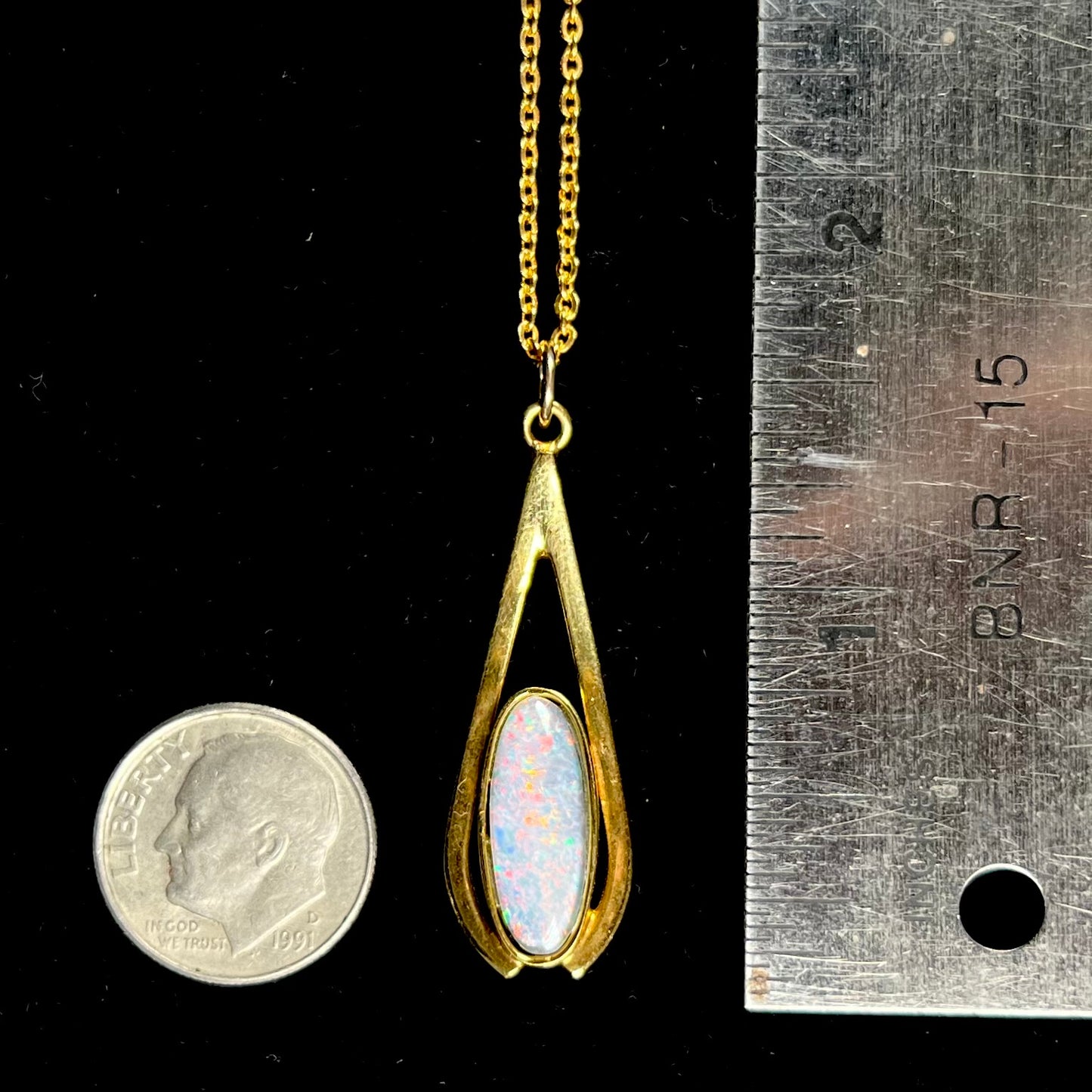 A yellow gold plated necklace set with an oval cut opal triplet.