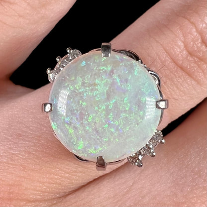 A round cut Australian opal and diamond engagment ring with platinum filigree.